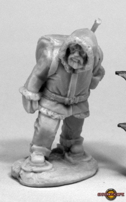 Minature figurine of a character in winter clothing on a gray background. Reaper Miniatures Antarctic Explorer plastic unpainted