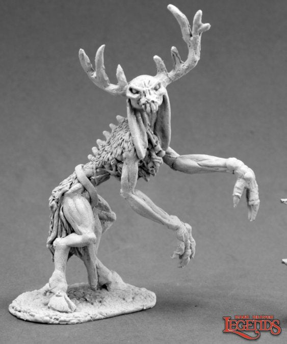 Gray-scale fantasy creature figurine with large antlers on a gray background. Wendigo. Reaper Miniatures metal unpainted.